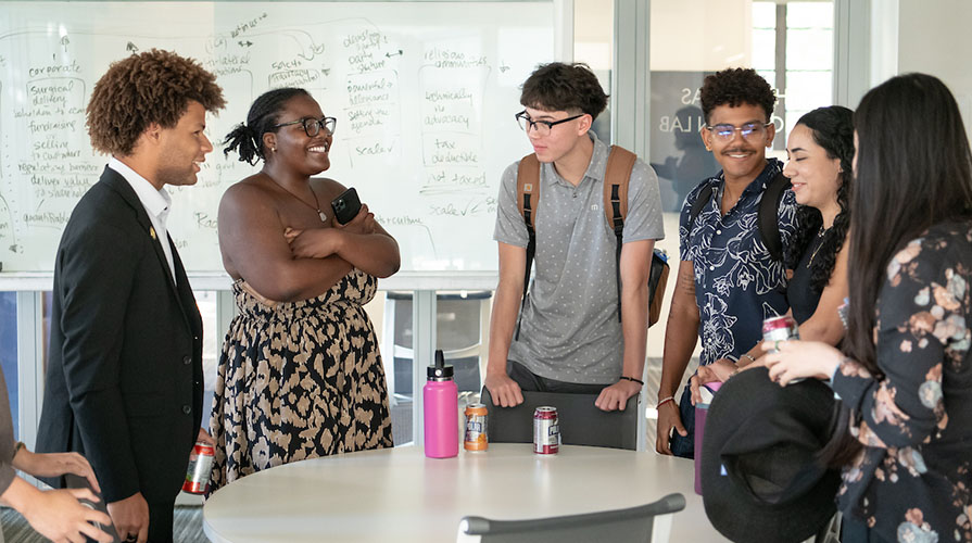 Jaymes Griggs hanging out with a group of other laughing Occidental College students