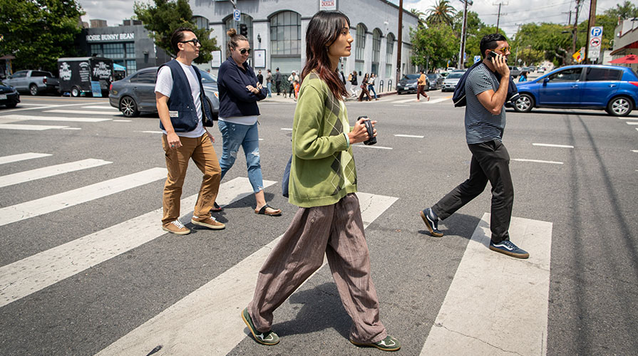 Qingxi Yang walks across street in Highland Park neighborhood